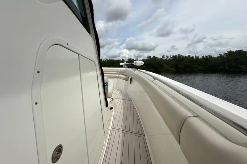 Slide: The Image of 2019 Boston Whaler 330 Outrage boat deck with scenic water and cloudy sky backdrop. - 22