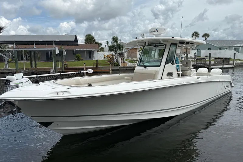 Slide: The Image of 2019 Boston Whaler 330 Outrage boat docked in a marina under cloudy skies. - 29
