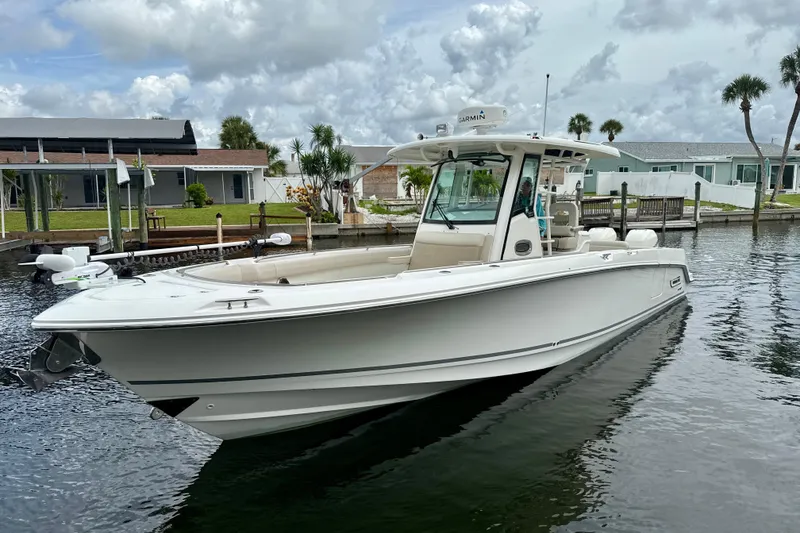 Slide: The Image of 2019 Boston Whaler 330 Outrage boat docked in a scenic waterfront setting. - 30