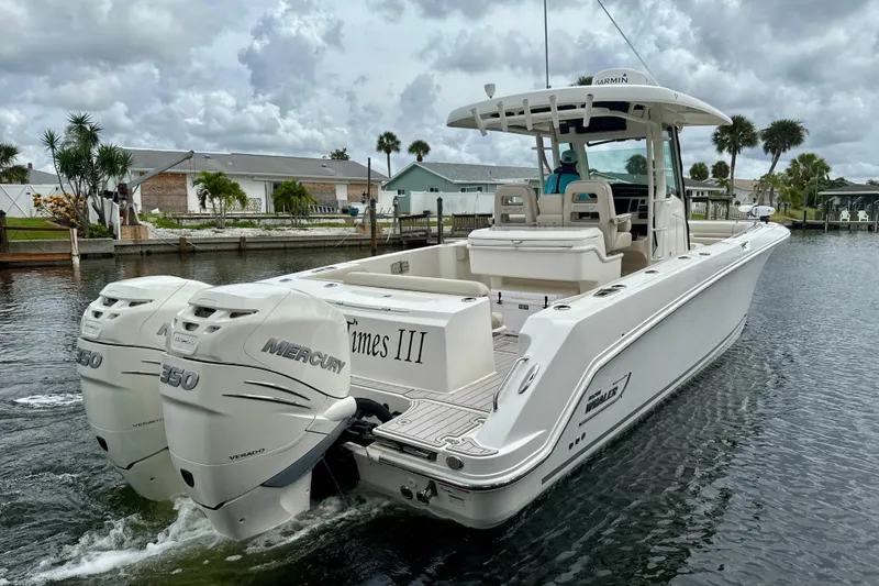 Slide: The Image of 2019 Boston Whaler 330 Outrage boat with twin Mercury 350 engines on a calm waterway. - 31