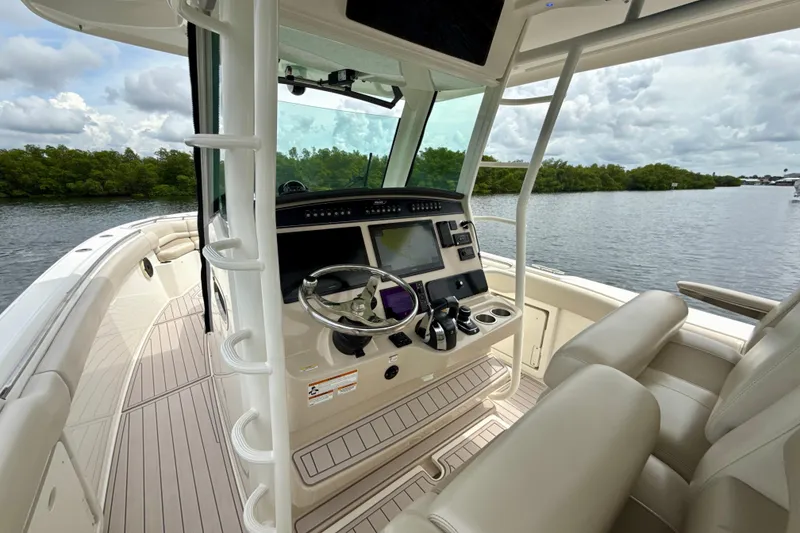 Slide: The Image of 2019 Boston Whaler 330 Outrage boat interior with helm, steering wheel, and seating. - 4
