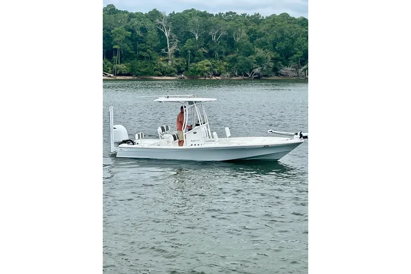 The Image of 2022 BlackJack 224 boat on calm water with person standing at helm. - 0