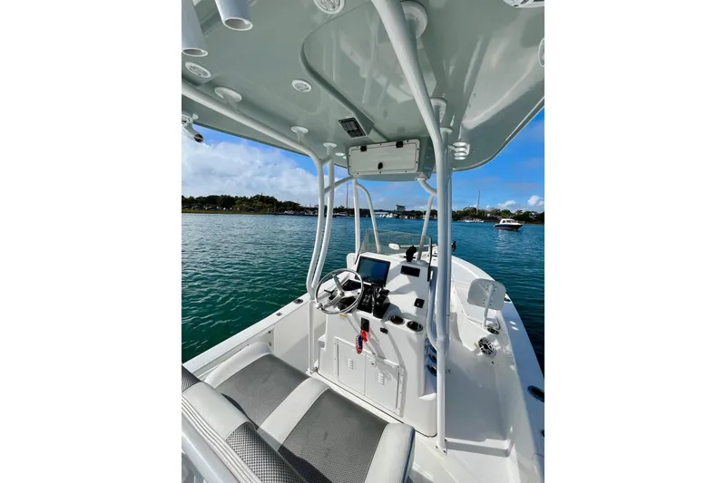 Slide: The Image of 2022 BlackJack 224 boat interior with steering console on calm water. - 11