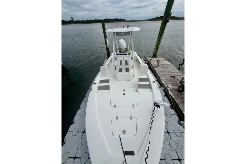 Slide: The Image of 2022 BlackJack 224 boat docked on a calm lake under cloudy skies. - 8