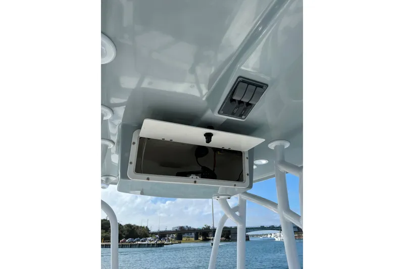 Slide: The Image of 2022 BlackJack 224 boat console with open storage compartment and control switches. - 9