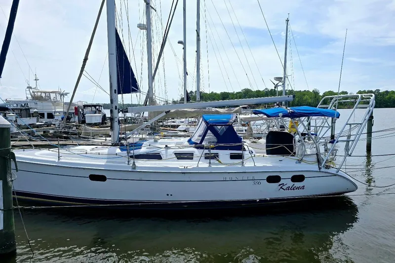 The Image of 2003 Hunter 386 sailboat docked at marina with blue canopy and clear sky. - 1