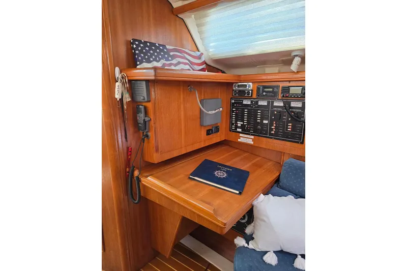Slide: The Image of Navigation station in 2003 Hunter 386 sailboat with control panels and American flag decor. - 11