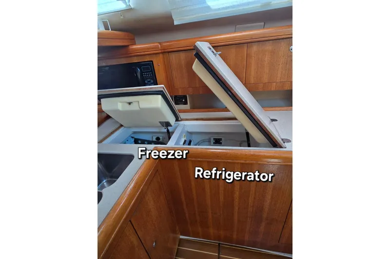 Slide: The Image of 2003 Hunter 386 yacht kitchen with open freezer and refrigerator compartments. - 17