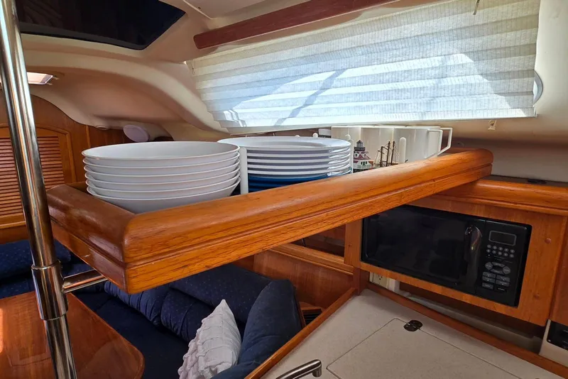 Slide: The Image of Interior of 2003 Hunter 386 yacht with plates and microwave in wooden cabinetry. - 18