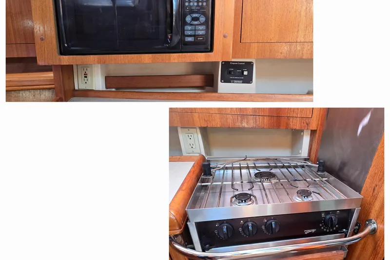 Slide: The Image of 2003 Hunter 386 yacht kitchen with microwave and stove, featuring wooden cabinetry. - 20