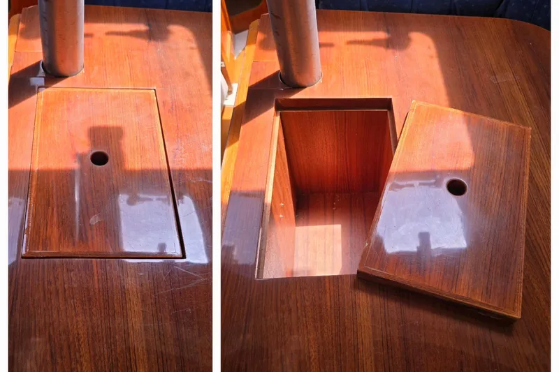 Slide: The Image of Wooden table with removable panel, revealing storage compartment on a 2003 Hunter 386 sailboat. - 24