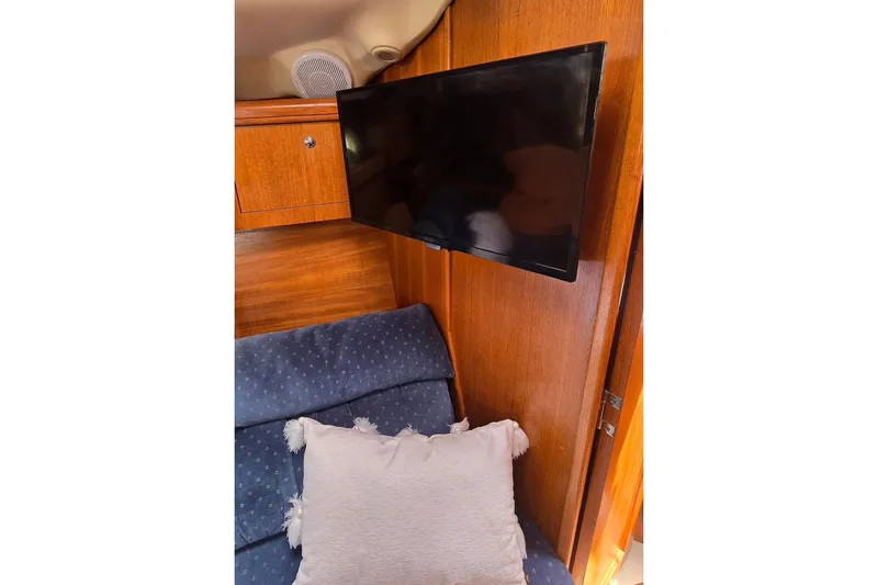 Slide: The Image of Interior of 2003 Hunter 386 yacht with TV and cushioned seating. - 25