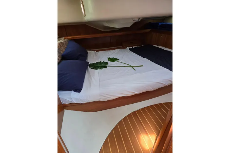 Slide: The Image of Cozy cabin interior of 2003 Hunter 386 sailboat with bed and decorative leaf. - 26