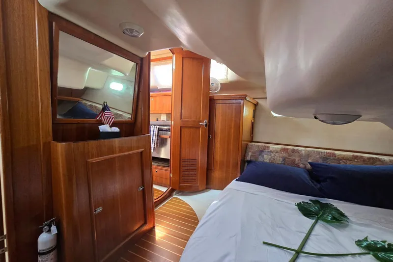 Slide: The Image of Interior of 2003 Hunter 386 sailboat with wooden cabinetry and cozy sleeping area. - 27