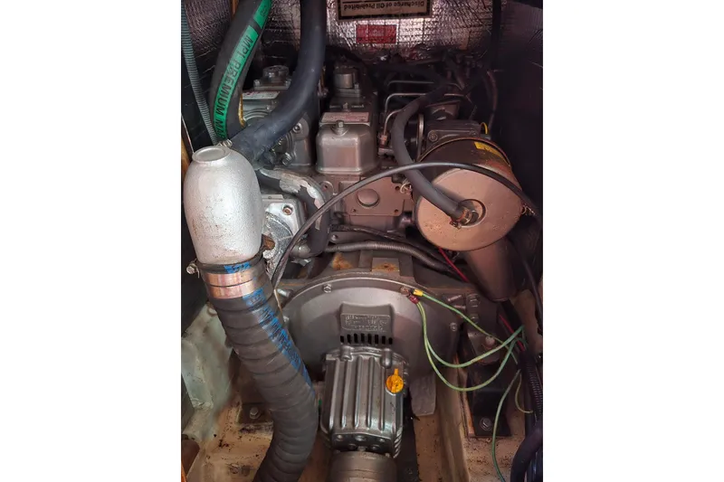 Slide: The Image of Engine compartment of a 2003 Hunter 386 sailboat, showing hoses and mechanical components. - 29