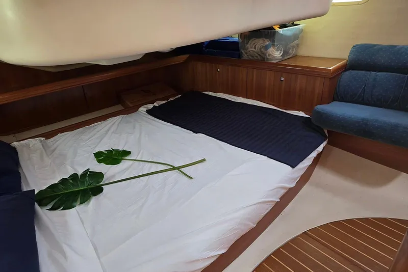 Slide: The Image of Cozy cabin interior of 2003 Hunter 386 sailboat with bedding and tropical leaves. - 30