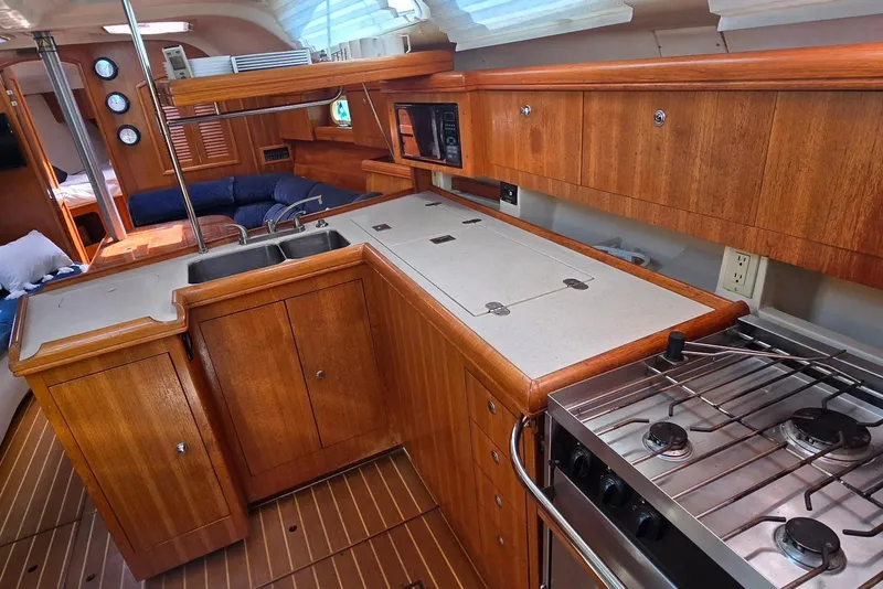 Slide: The Image of Interior of a 2003 Hunter 386 yacht featuring a wooden galley with stove and sink. - 33