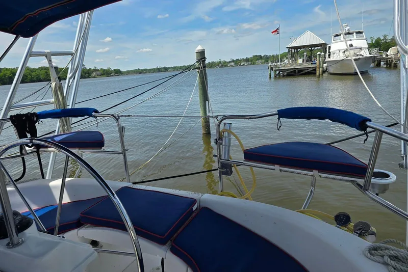 Slide: The Image of Cockpit view of a 2003 Hunter 386 sailboat docked by a serene waterfront. - 6