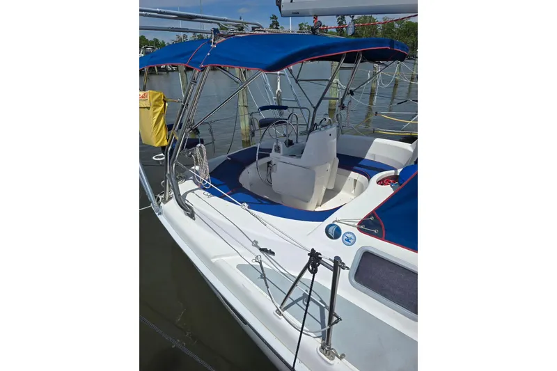 Slide: The Image of 2003 Hunter 386 sailboat with blue canopy docked at marina. - 8