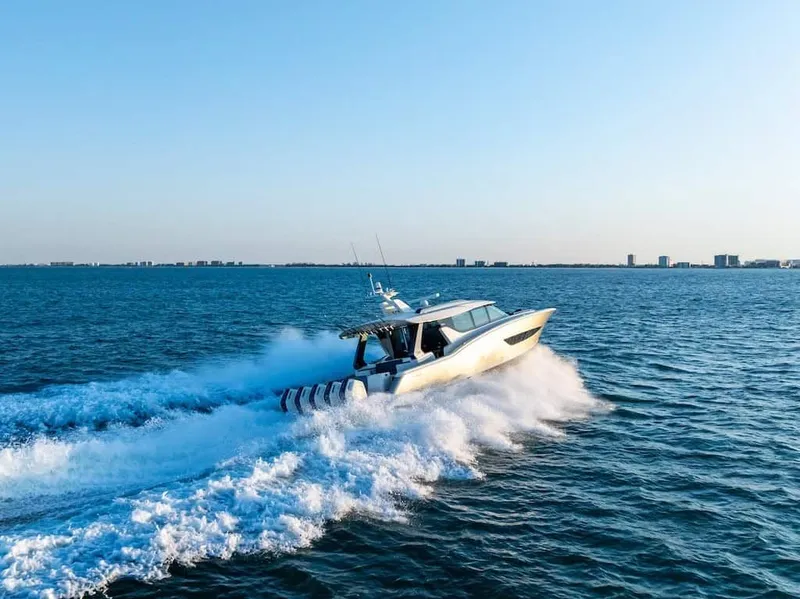 Slide: The Image of 2026 Scout 670 LX boat cruising on open water under clear blue sky. - 2