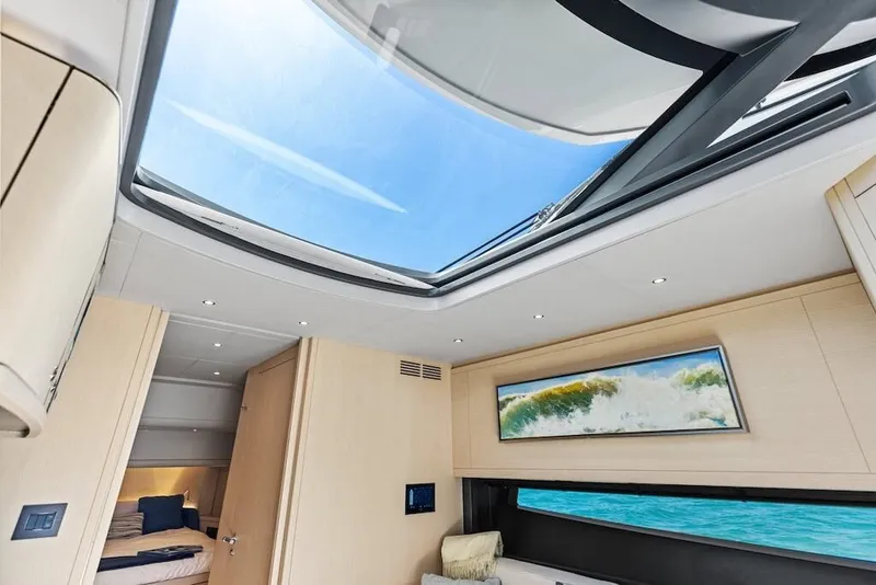 Slide: The Image of Interior of 2026 Scout 670 LX yacht with skylight and ocean view painting. - 30