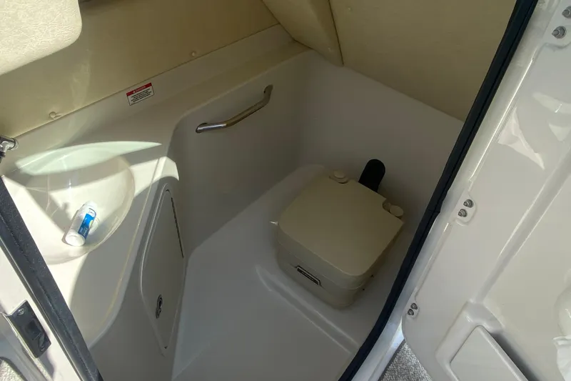 Slide: The Image of 2008 Sea Ray 260 Sundeck interior with portable toilet and storage area. - 11