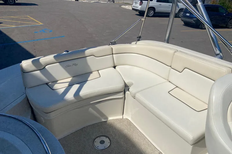 Slide: The Image of 2008 Sea Ray 260 Sundeck interior with white seating in a parking lot. - 5