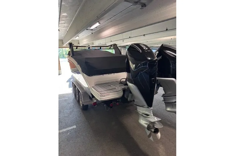Slide: The Image of 2019 Sea Ray SDX 290 Outboard boat with dual engines in a covered parking area. - 12