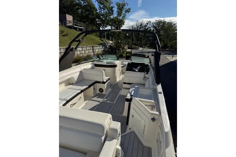 Slide: The Image of 2019 Sea Ray SDX 290 Outboard boat interior with seating and helm, docked outdoors. - 2