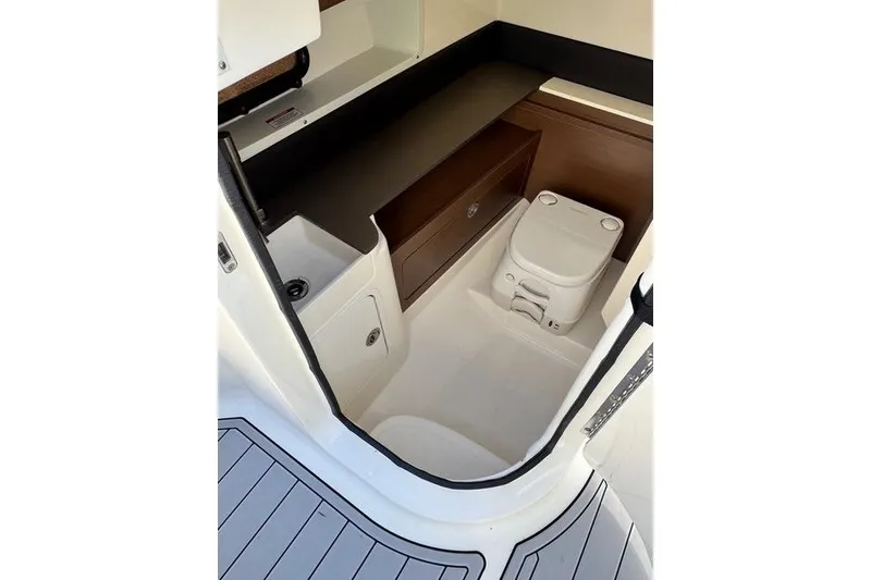 Slide: The Image of 2019 Sea Ray SDX 290 Outboard interior with compact marine toilet and storage. - 20