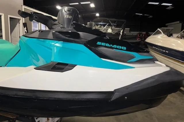 Slide: The Image of 2021 Sea-Doo GTX jet ski in a showroom, featuring a sleek turquoise and white design. - 3