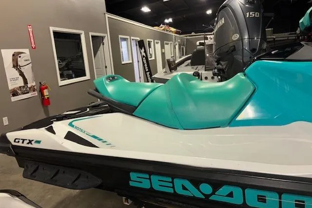 Slide: The Image of 2021 Sea-Doo GTX jet ski with teal seat in showroom. - 4