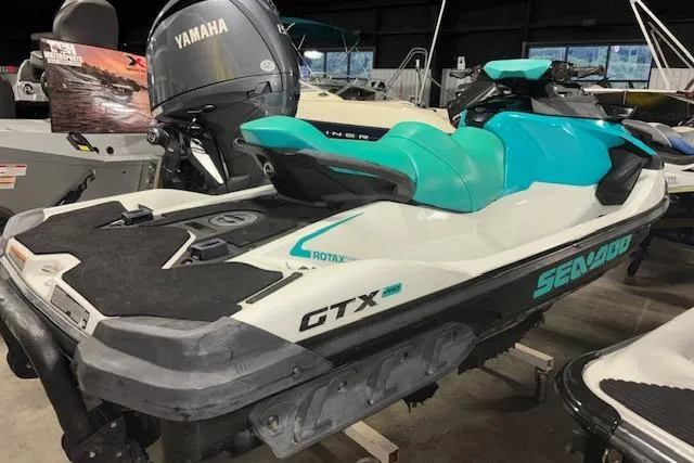 Slide: The Image of 2021 Sea-Doo GTX personal watercraft in a showroom, featuring a sleek design and turquoise accents. - 7