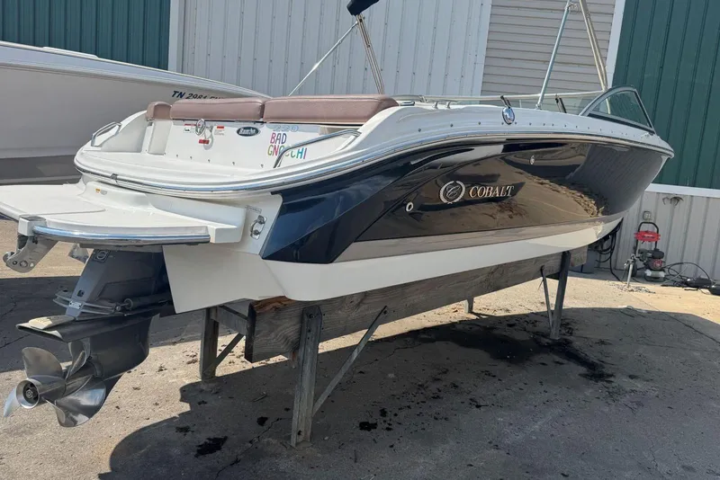 Slide: The Image of 2013 Cobalt 220 boat on a stand, showcasing sleek design and powerful engine. - 11