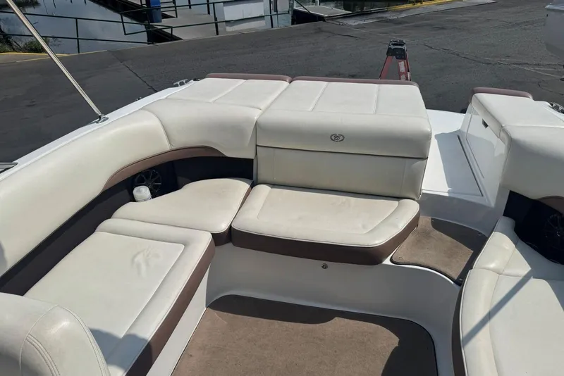 Slide: The Image of 2013 Cobalt 220 boat interior with white and brown seating, docked at marina. - 15