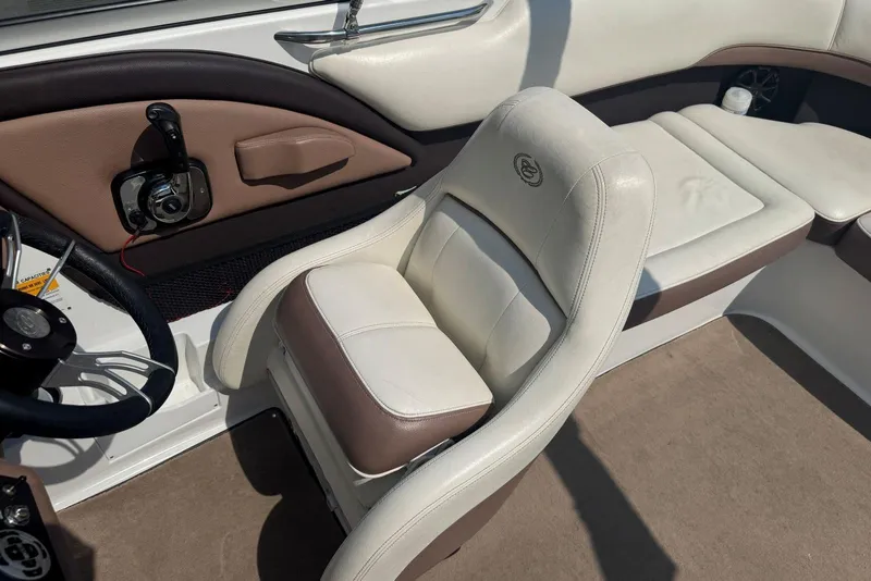 Slide: The Image of 2013 Cobalt 220 boat interior with white and brown seating and steering wheel. - 17