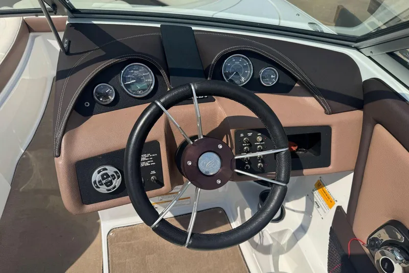 Slide: The Image of Steering wheel and dashboard of a 2013 Cobalt 220 boat, featuring gauges and controls. - 19