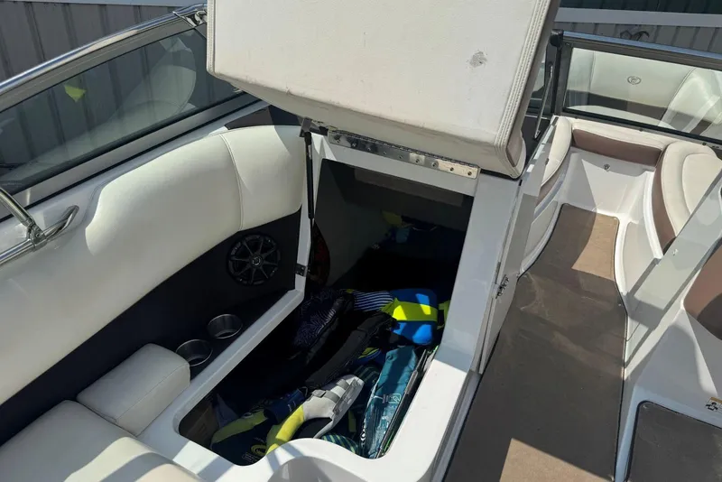 Slide: The Image of 2013 Cobalt 220 boat interior with open storage compartment and seating area. - 21