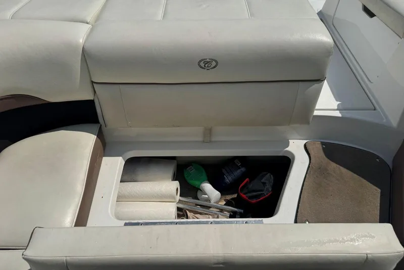 Slide: The Image of Storage compartment in a 2013 Cobalt 220 boat with various items inside. - 23