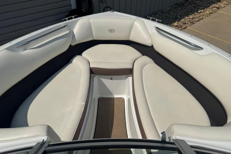 Slide: The Image of 2013 Cobalt 220 boat interior with white cushioned seating and sleek design. - 29