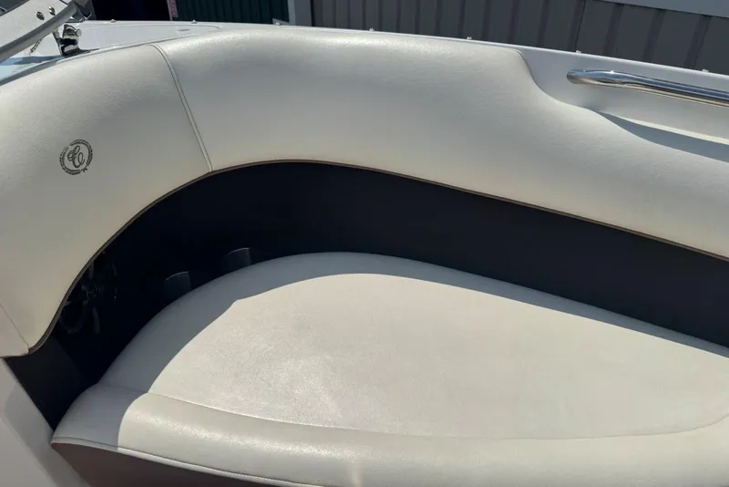 Slide: The Image of 2013 Cobalt 220 boat interior with white cushioned seating and metal handrail. - 33