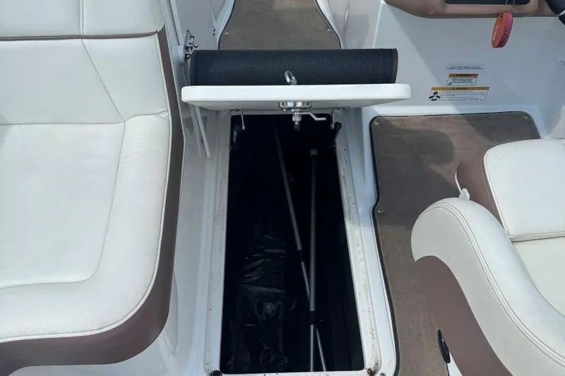 Slide: The Image of 2013 Cobalt 220 boat interior with open storage compartment and white seating. - 35