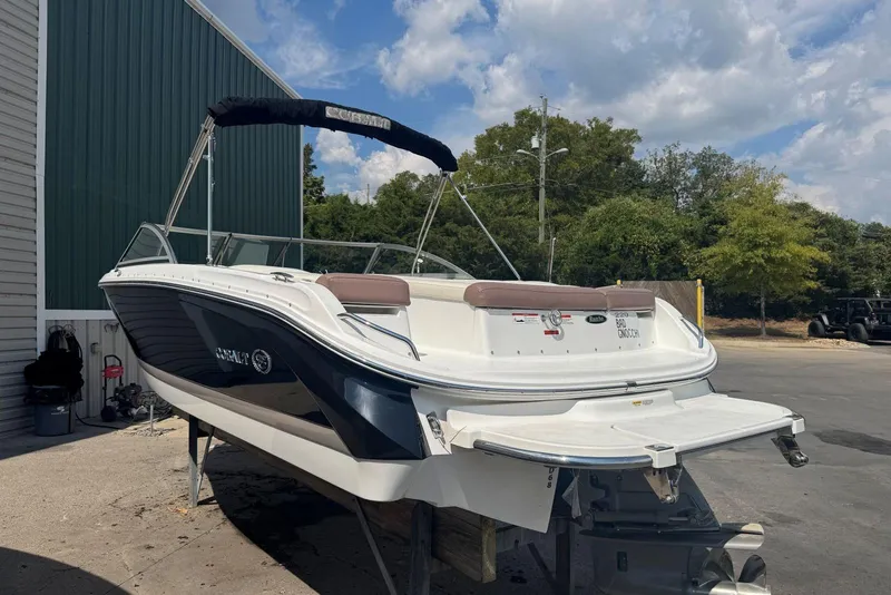 Slide: The Image of 2013 Cobalt 220 boat on trailer, parked outdoors near green building. - 5