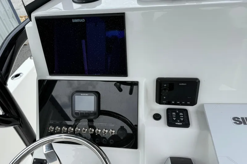 Slide: The Image of 2023 Sea Pro 248 Bay boat dashboard with Simrad and Suzuki controls. - 13
