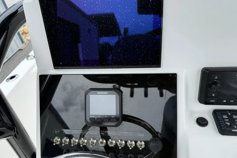 Slide: The Image of 2023 Sea Pro 248 Bay boat dashboard with Suzuki display and control panel. - 14