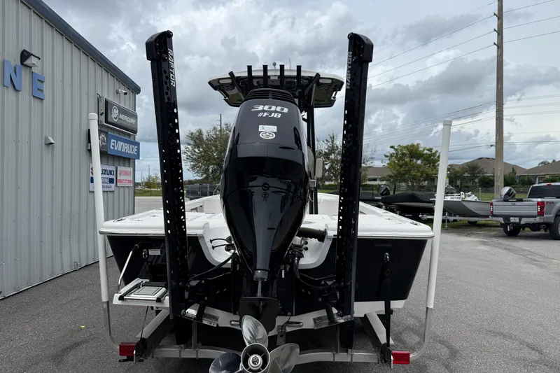 Slide: The Image of 2023 Sea Pro 248 Bay boat with powerful outboard motor, parked near marine dealership. - 24