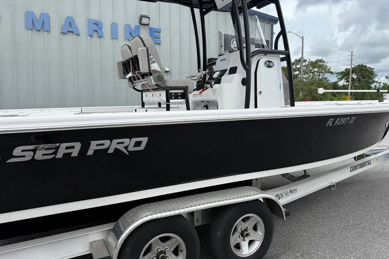 Slide: The Image of 2023 Sea Pro 248 Bay boat on trailer, parked outside marine facility. - 26
