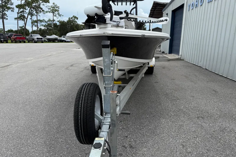 Slide: The Image of 2023 Sea Pro 248 Bay boat on trailer, parked outside a metal building. - 3