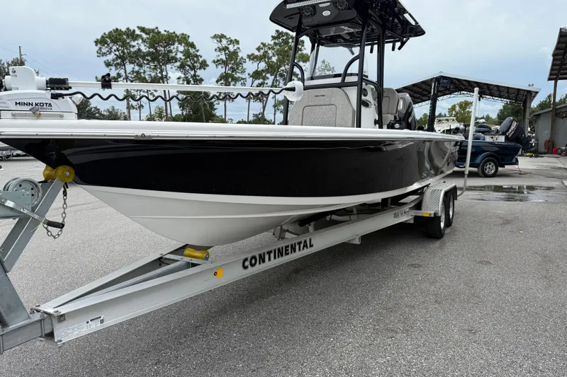 Slide: The Image of 2023 Sea Pro 248 Bay boat on trailer, black and white design, parked outdoors. - 4