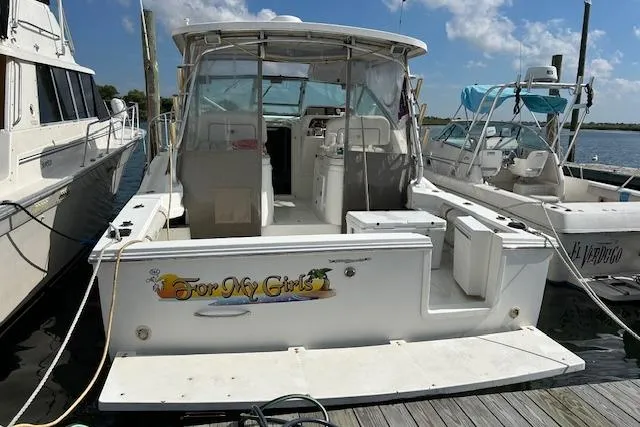Slide: The Image of 2001 Wellcraft 330 Coastal boat docked at marina under clear skies. - 2